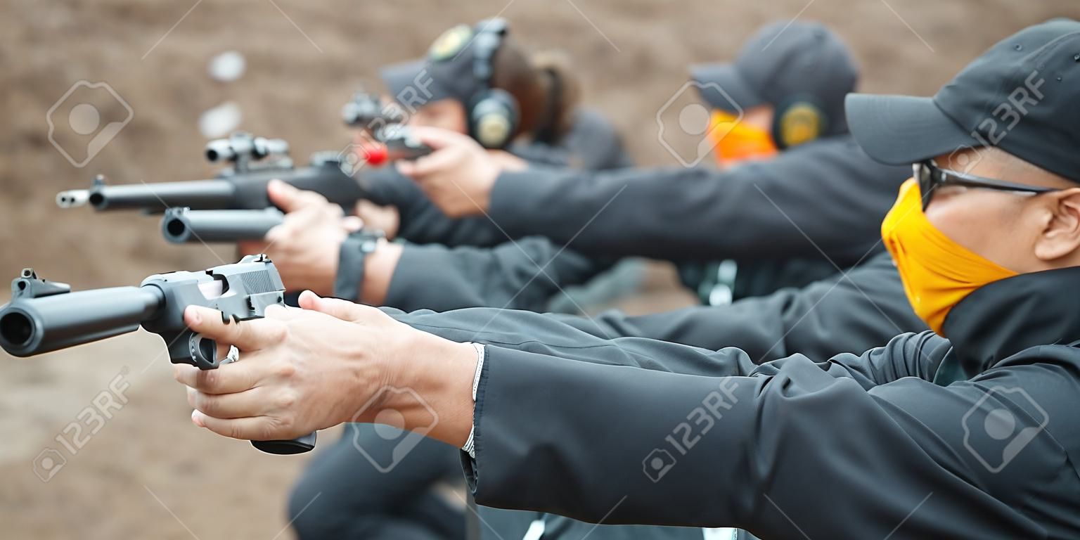 Groupe de tir au pistolet d'entraînement civil sur cible sur un champ de tir extérieur. Entraînement aux armes de l'équipe civile