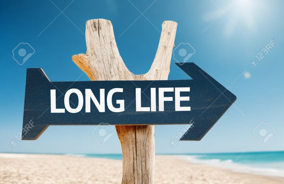 segno di lunga vita con la freccia su sfondo spiaggia