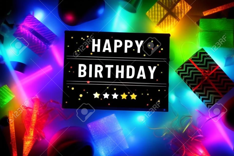 Let's celebrate concepts with happy  birthday text on cinema light box and colorful element prop on dark background.funny activity ideas