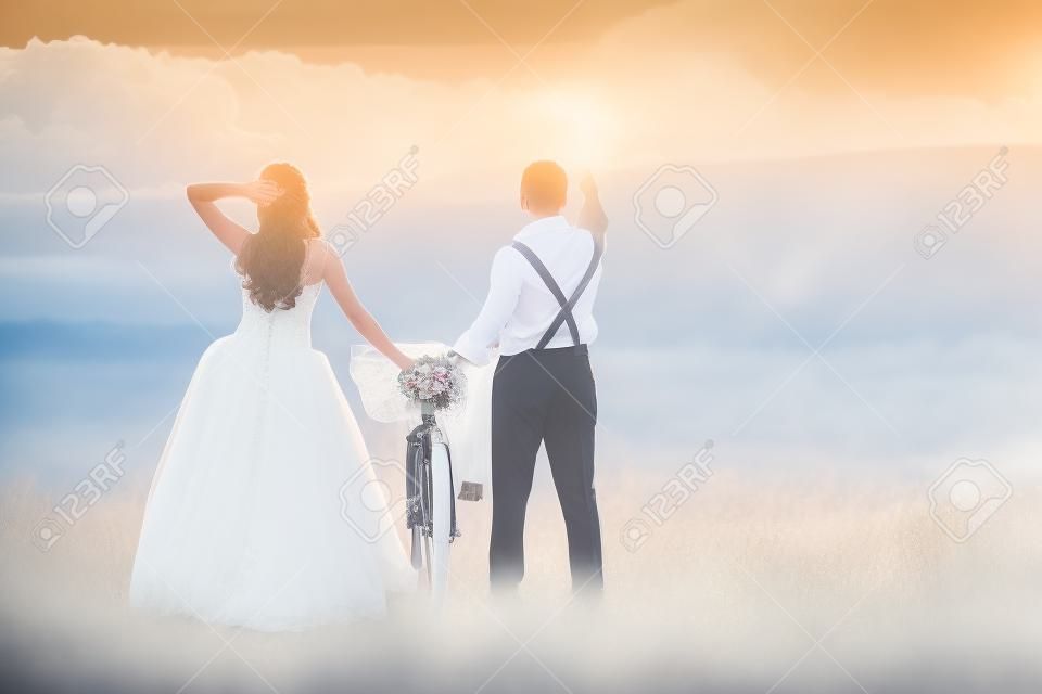 Prachtige bruid en bruidegom bruiloft portret met witte fiets