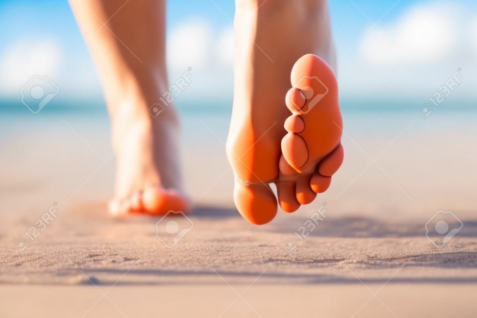 Detail van vrouwelijke blote voeten op zonnig strand