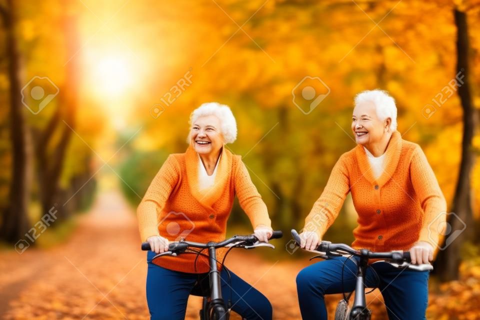 Aktive Senioren Reiten Fahrrad in der Natur im Herbst. Sie entspannen im Freien.