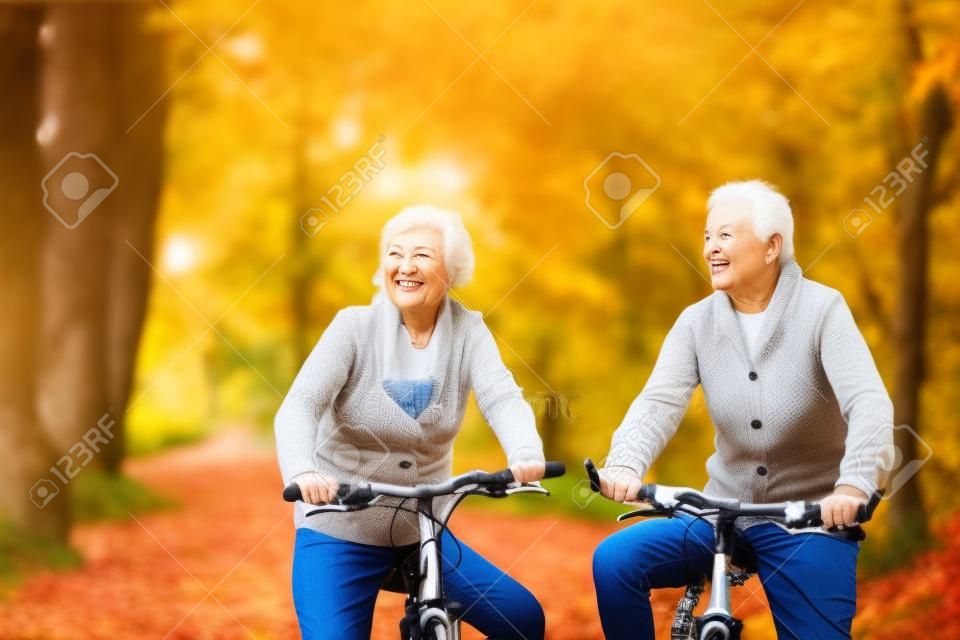 Aktive Senioren Reiten Fahrrad in der Natur im Herbst. Sie entspannen im Freien.