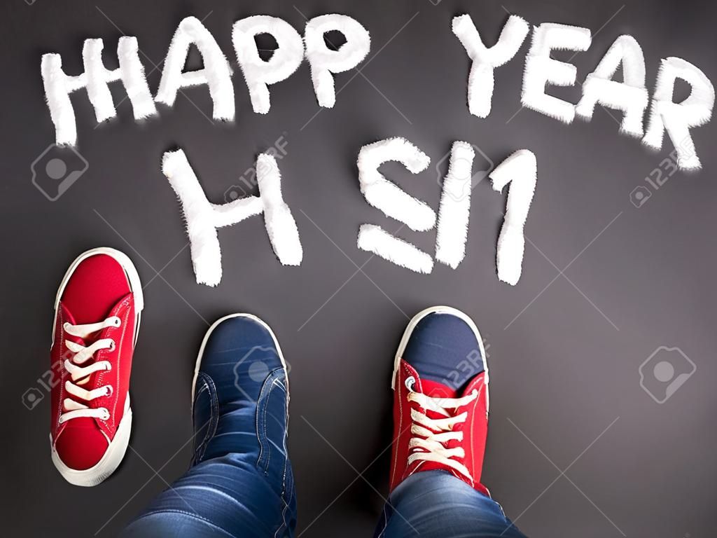 New year christmas concept with red sneakers and white chalk text on black floor