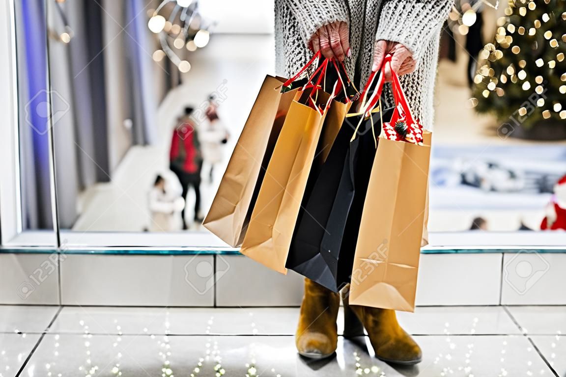 Senior woman with bags doing Christmas shopping.
