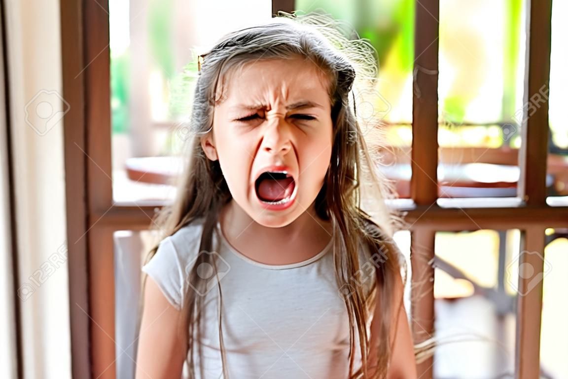 Porträt eines wütenden kleinen Mädchens im Haus, das weint.