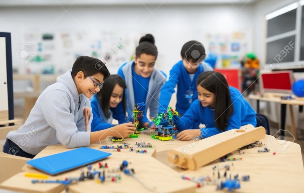 Group of students building and programming electric toys and robots at robotics classroom