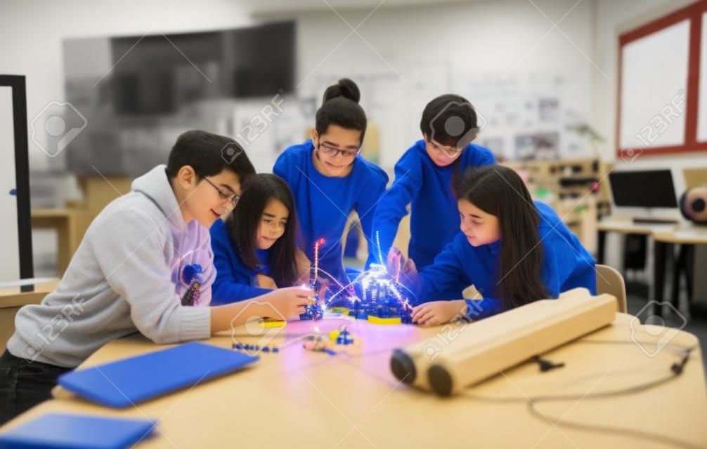 로봇 교실에서 전기 장난감과 로봇을 만들고 프로그래밍하는 학생 그룹