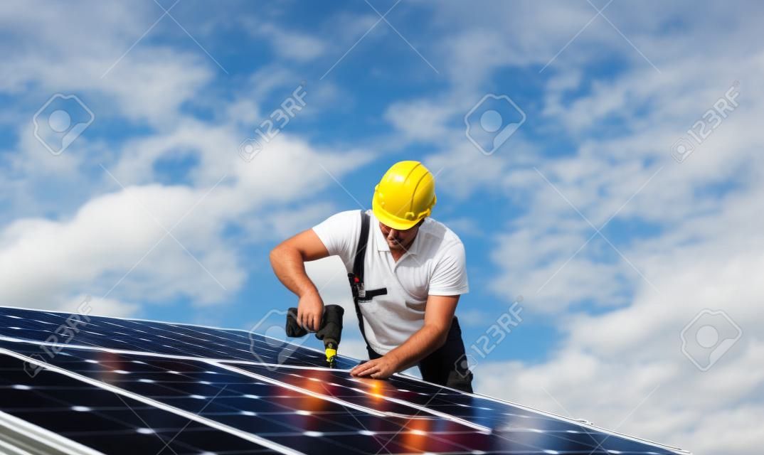 Travailleur de l'homme installant des panneaux solaires photovoltaïques sur le toit, concept d'énergie alternative.