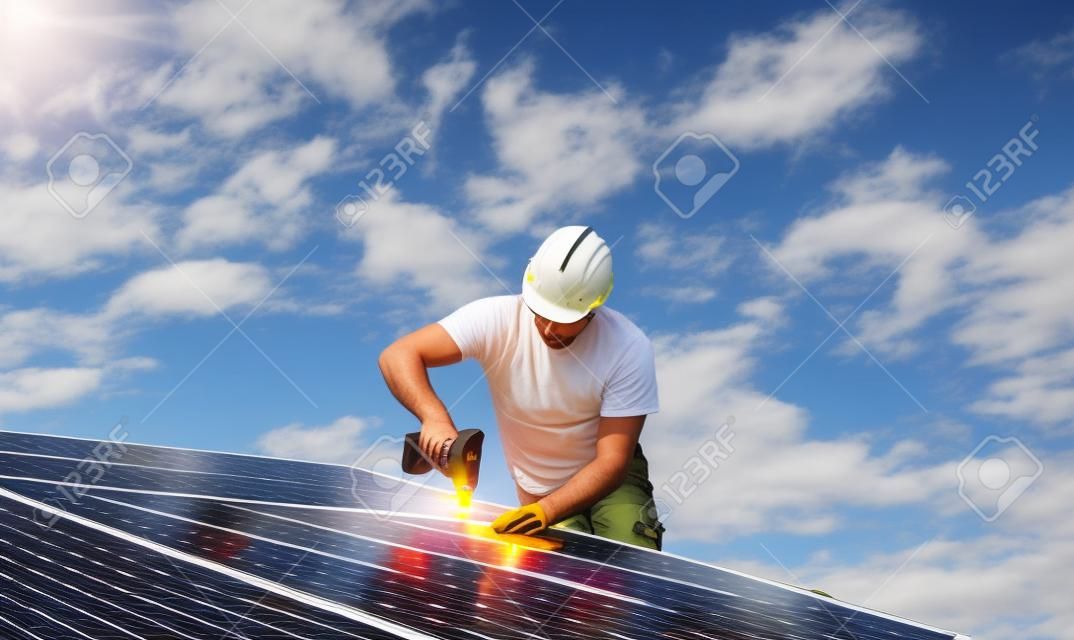Travailleur de l'homme installant des panneaux solaires photovoltaïques sur le toit, concept d'énergie alternative.