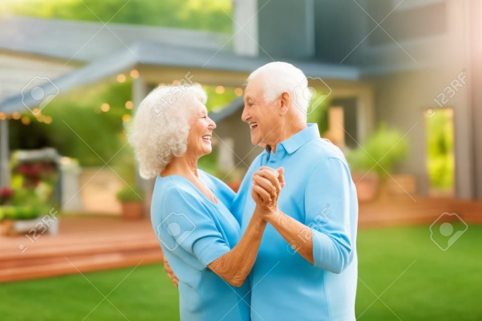 Donna anziana e uomo che ballano insieme in un giardino d'estate