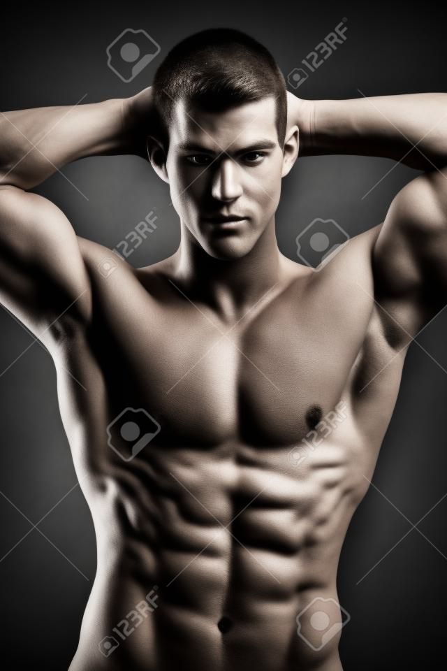 Healthy muscular young man  Isolated on black background   Shallow DoF with focus on face 