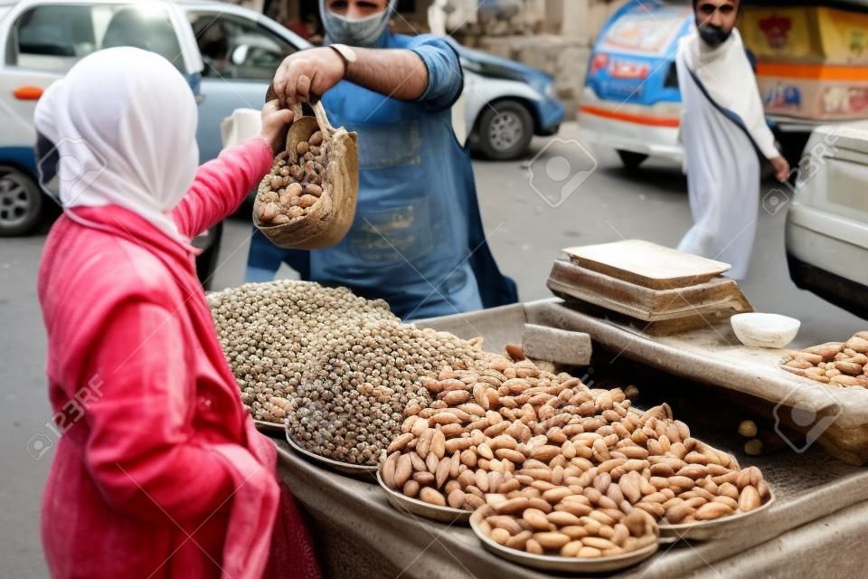 Vendedor vendendo amêndoas frescas na rua em damasco, síria