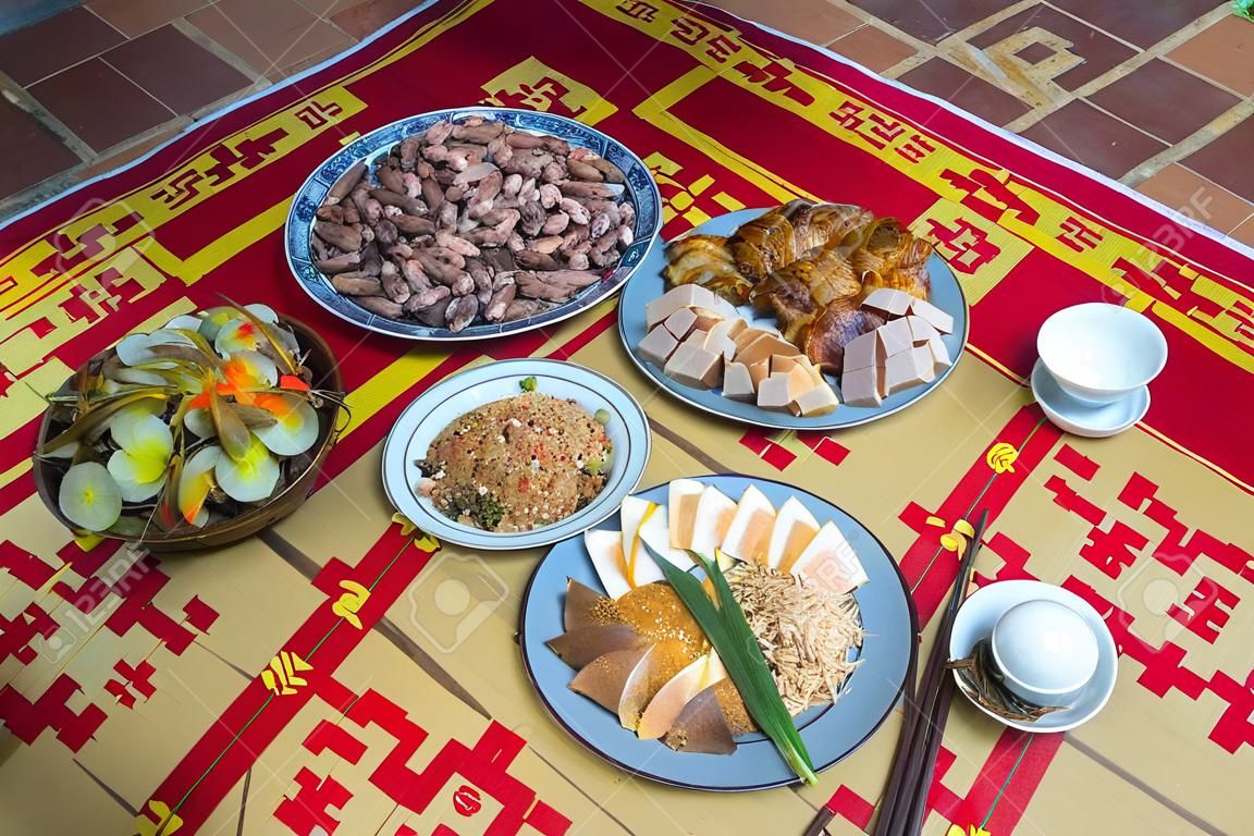 Un pasto tradizionale vietnamita per la festa del capodanno lunare Tet in primavera, collocato su un nuovo tappetino di carice fiorito, l'ultimo giorno dell'anno scorso
