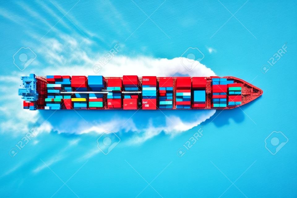 Aerial top down view of a large container ship in motion over blue, open ocean; global transport of cargo on sea