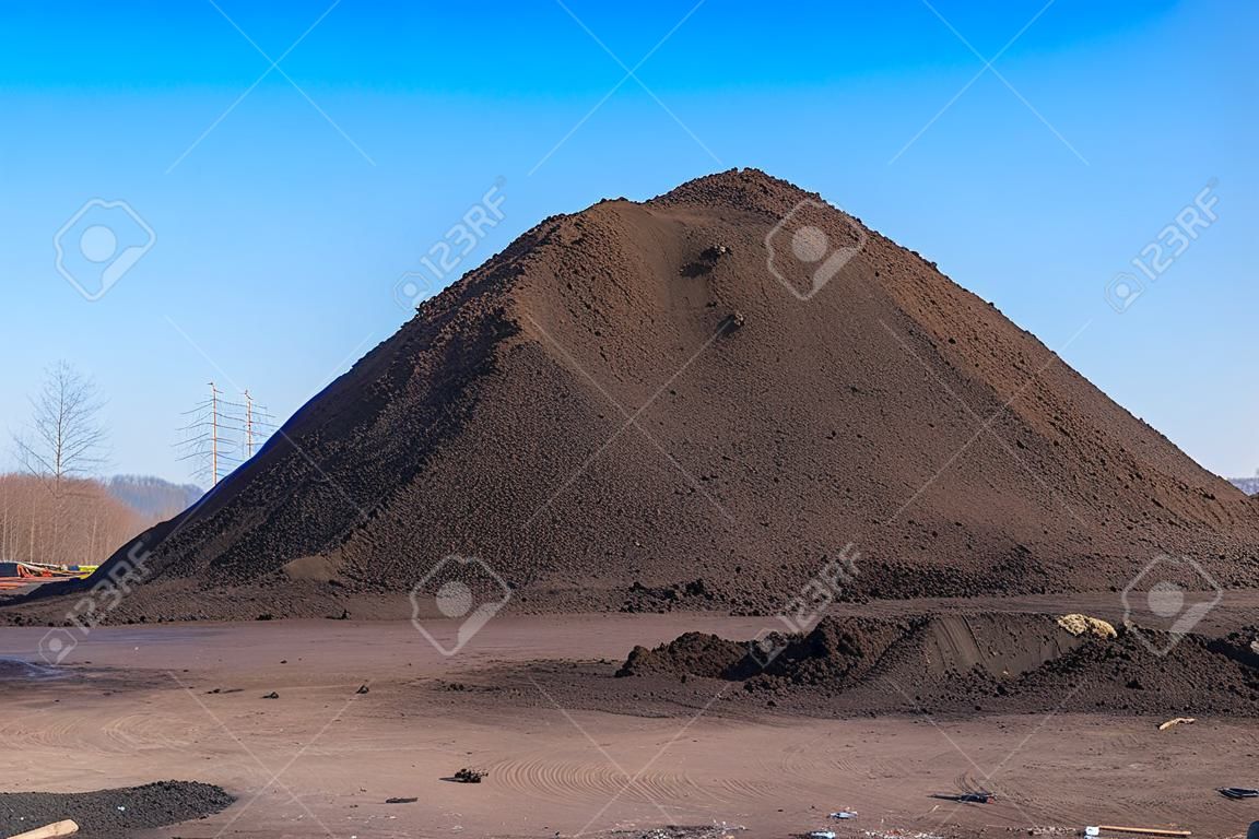 куча черного песка на стройке