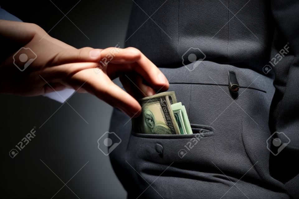 Un voleur prend un portefeuille avec de l'argent dans une poche d'un homme en costume, un homme d'affaires, un crime, une poche