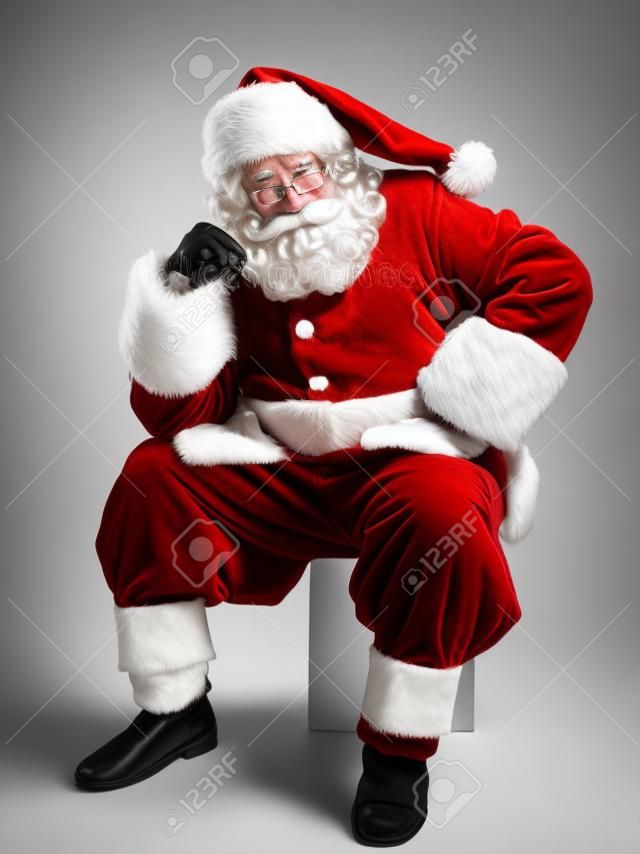 Weihnachtsmann-Porträt sitzt nachdenklich auf weißen Hintergrund