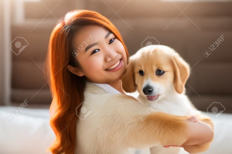Giovane donna asiatica che gioca con il cane a casa