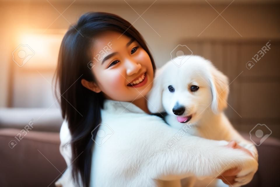 Giovane donna asiatica che gioca con il cane a casa
