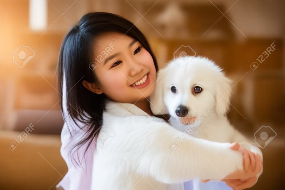 집에서 개와 노는 젊은 아시아 여성