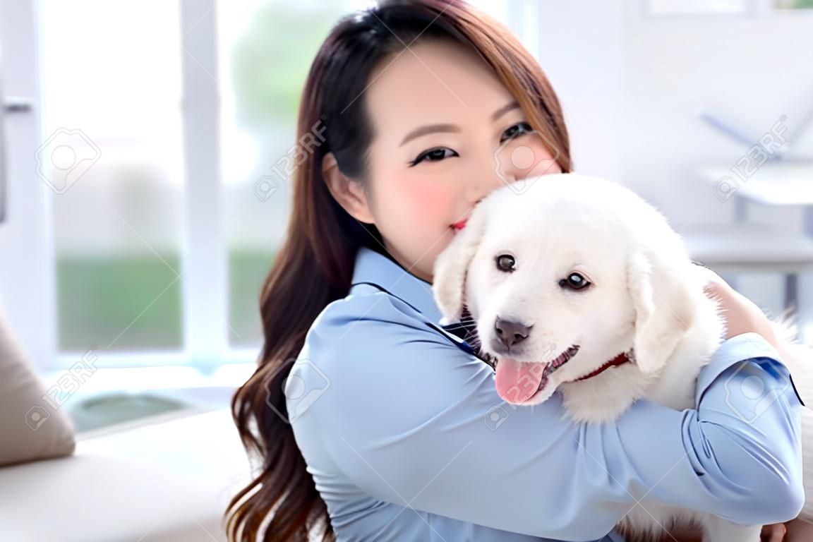 집에서 개와 노는 젊은 아시아 여성