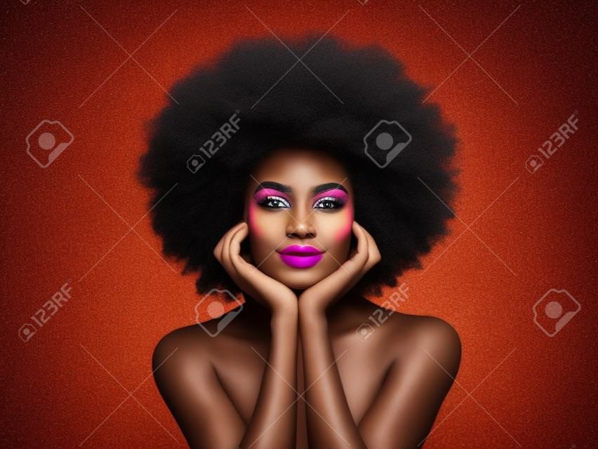 Schönheitsporträt eines afroamerikanischen Mädchens mit bunt gefärbtem Afro-Haar. Schöne schwarze Frau. Kosmetik, Make-up und Mode