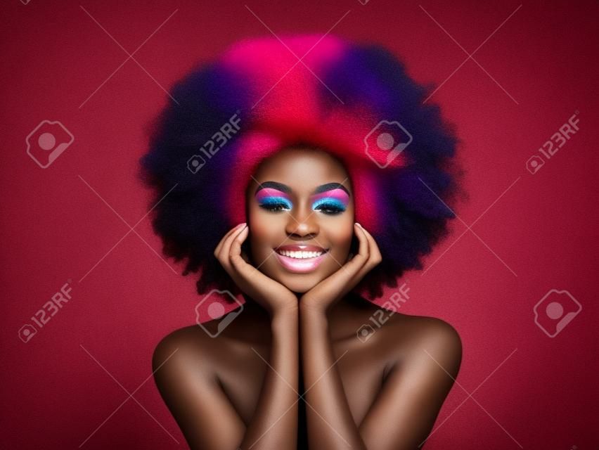 Schönheitsporträt eines afroamerikanischen Mädchens mit bunt gefärbtem Afro-Haar. Schöne schwarze Frau. Kosmetik, Make-up und Mode