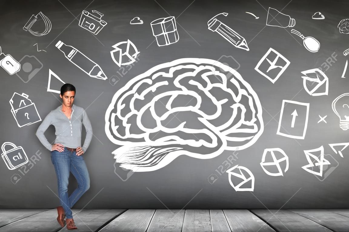 Femme se tient à côté de grand cerveau dessiné sur le mur gris