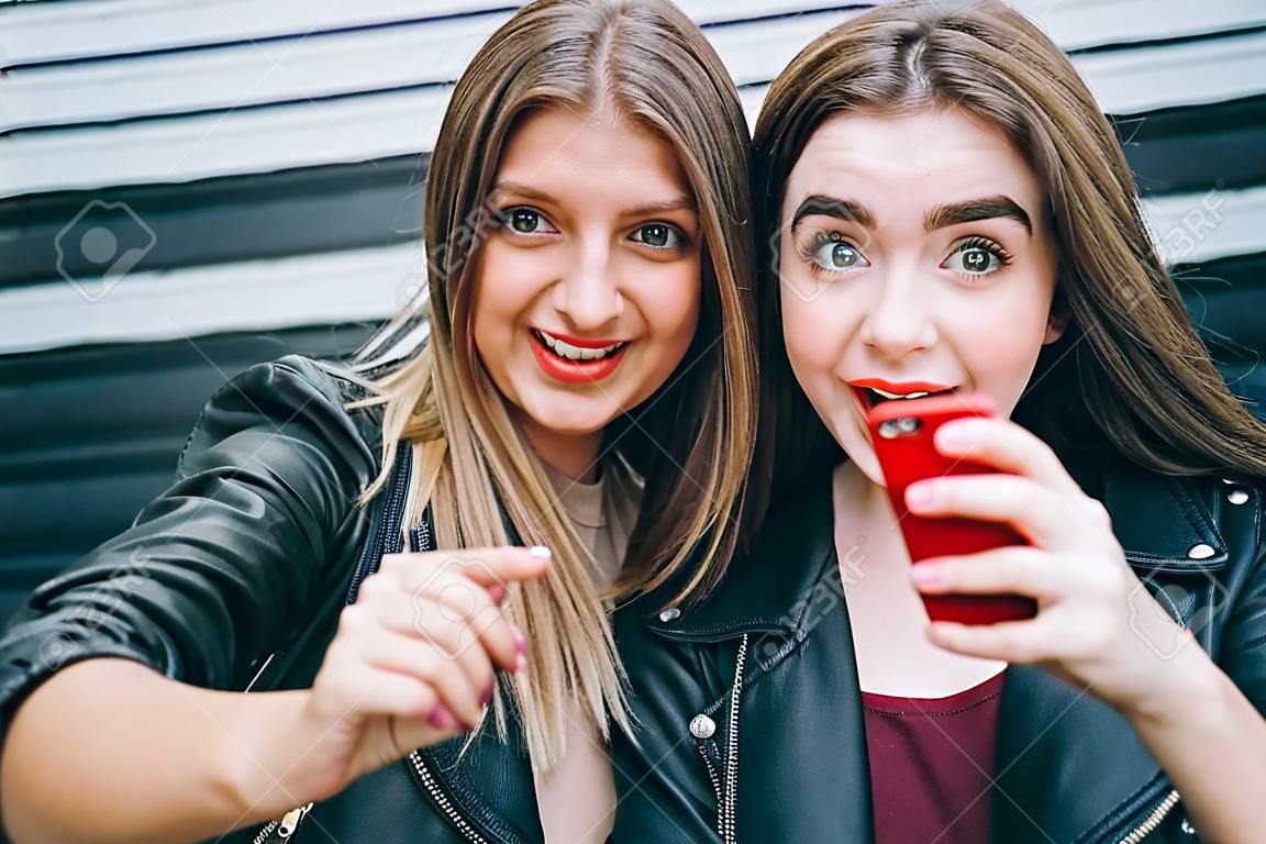 Zwei junge Mädchen , die selfie unter Verwendung des Smartphone nehmen