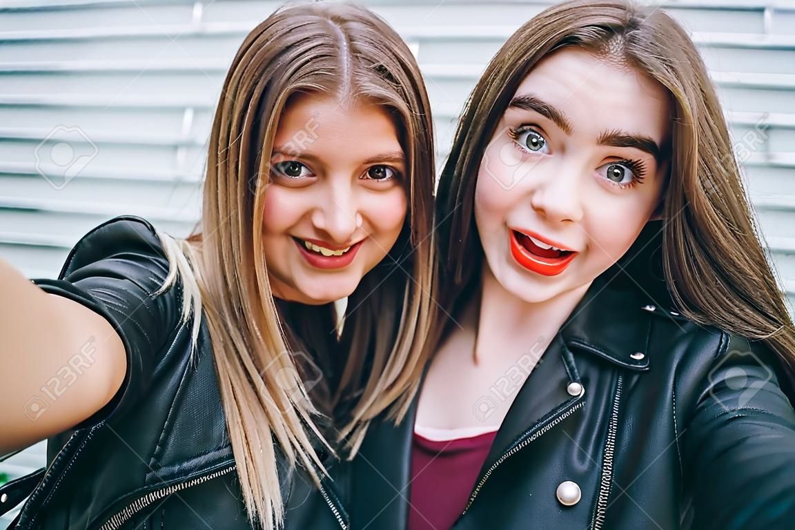 Two young girls taking selfie using smartphone