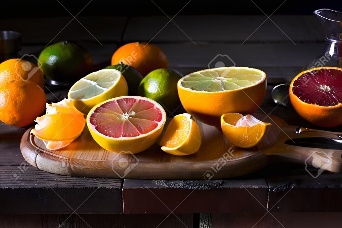 various types of citrus fruit on a dark wooden background. Classic Still Life