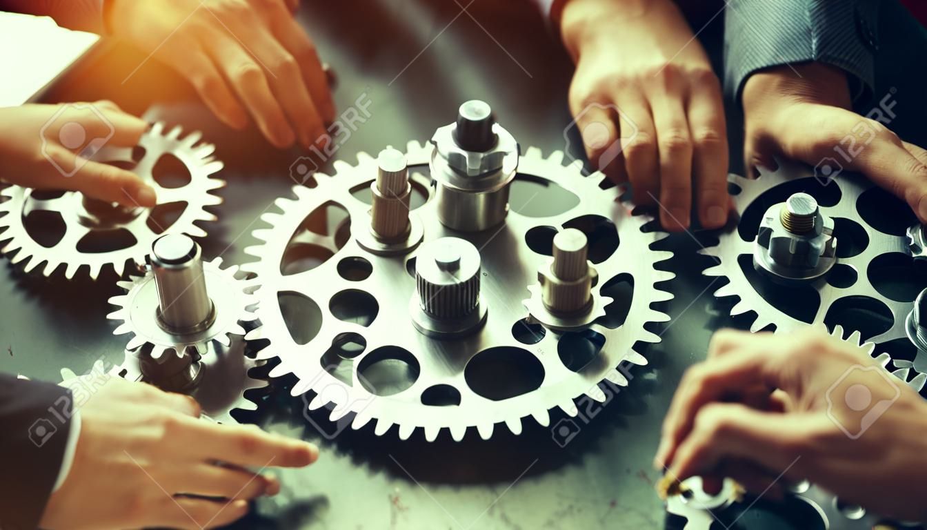 Group of business people working together on gears mechanism in the office.