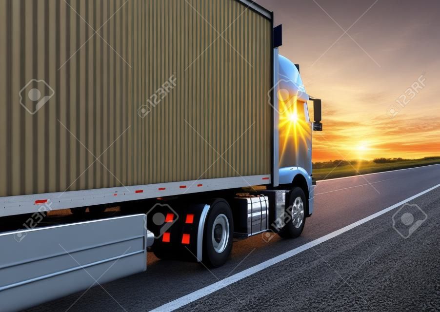 a truck with an isotherm semitrailer transports cargo along the highway against the backdrop of an evening sunset. Concept of delivery of goods, cargo transportation