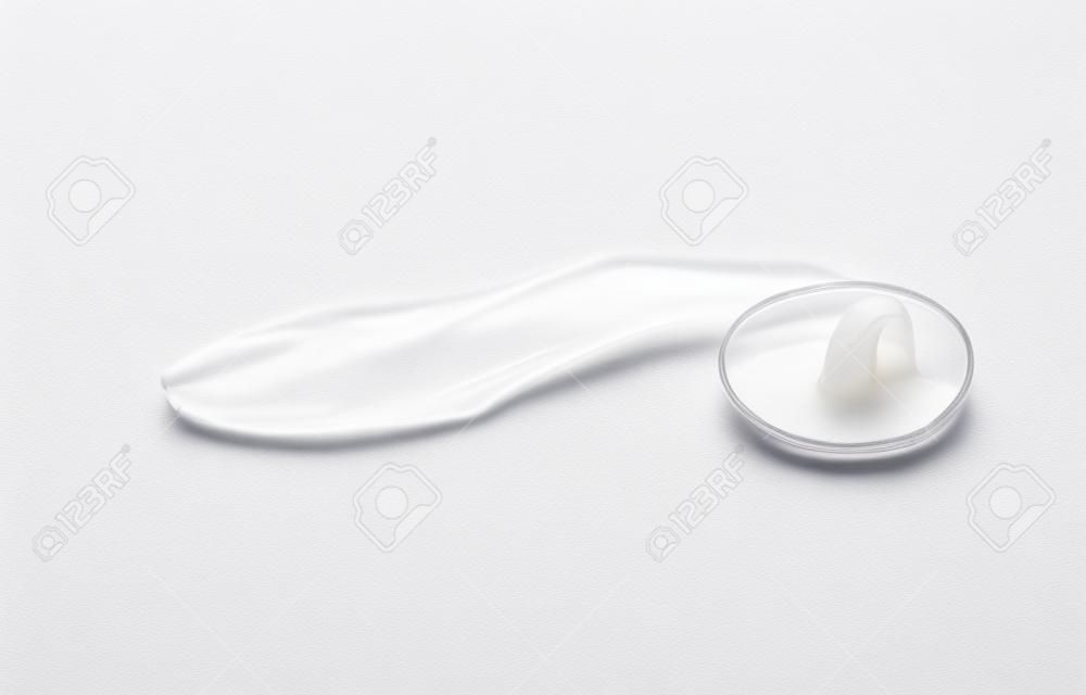 Zużyta prezerwatywa z nasieniem w środku, rzucona na ziemię. na białym tle. . zdjęcie wysokiej jakości