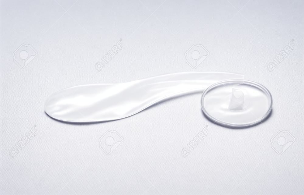 Zużyta prezerwatywa z nasieniem w środku, rzucona na ziemię. na białym tle. . zdjęcie wysokiej jakości