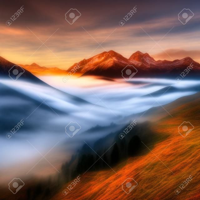 Paesaggio montano con nebbia nella valle al tramonto