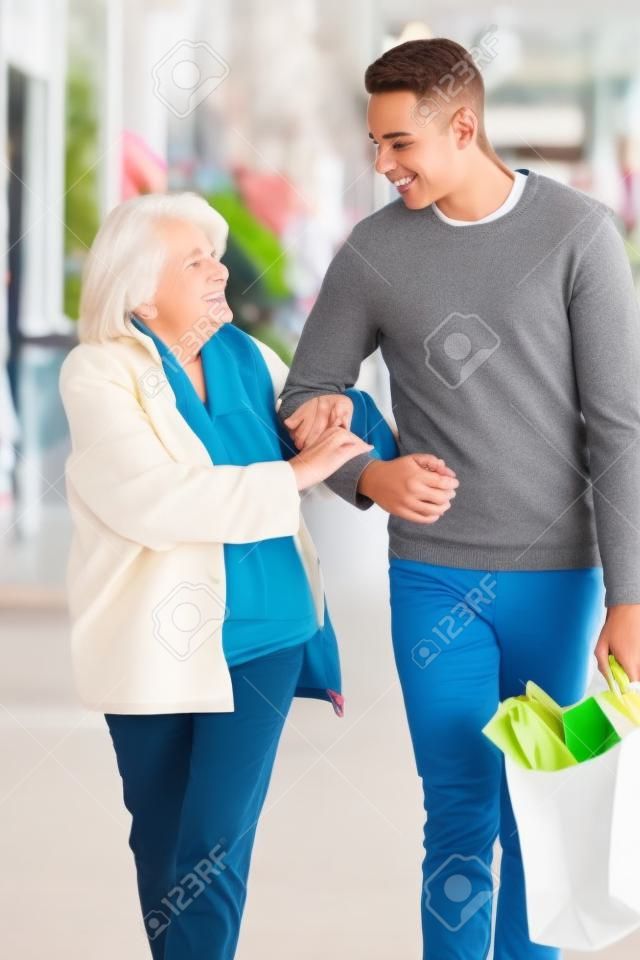 Adolescente ajudando mulher sênior para levar compras