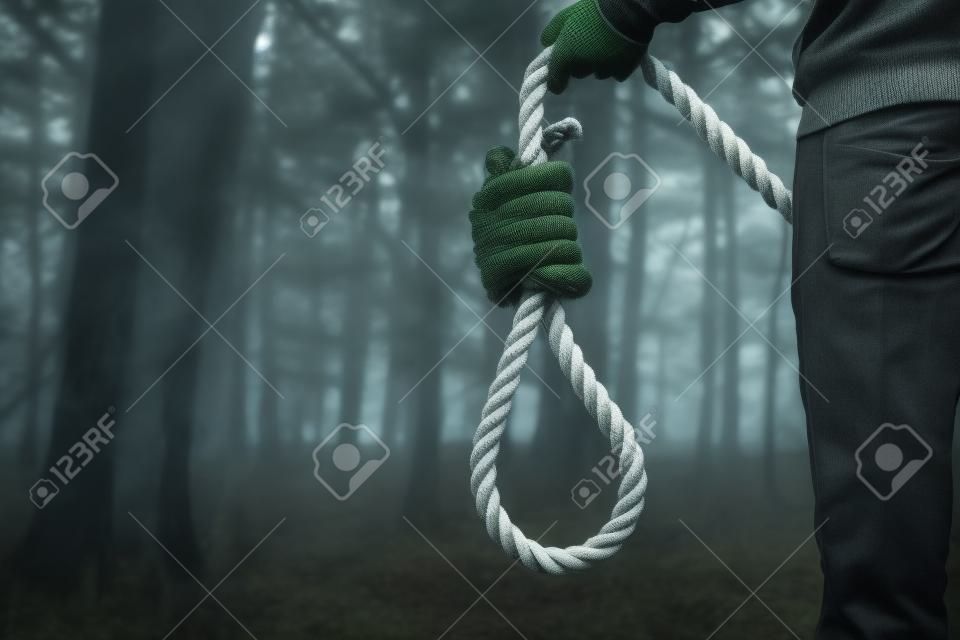 Depresso uomo contemplare il suicidio per impiccagione In Foresta