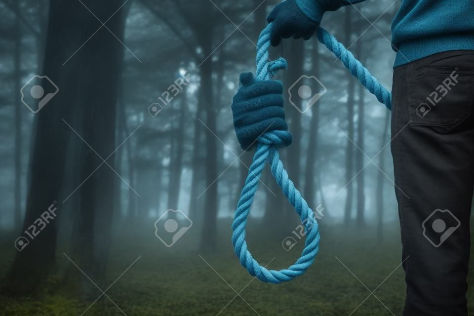 Depressed man holding a noose in the forest