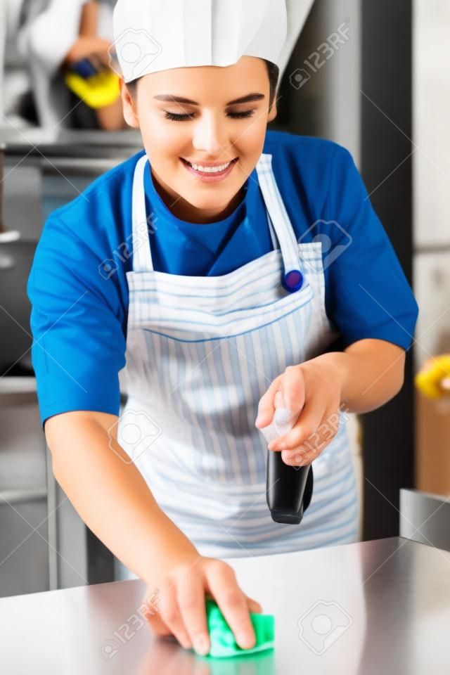 Worker In Restaurant Kitchen Cleaning Down After Service