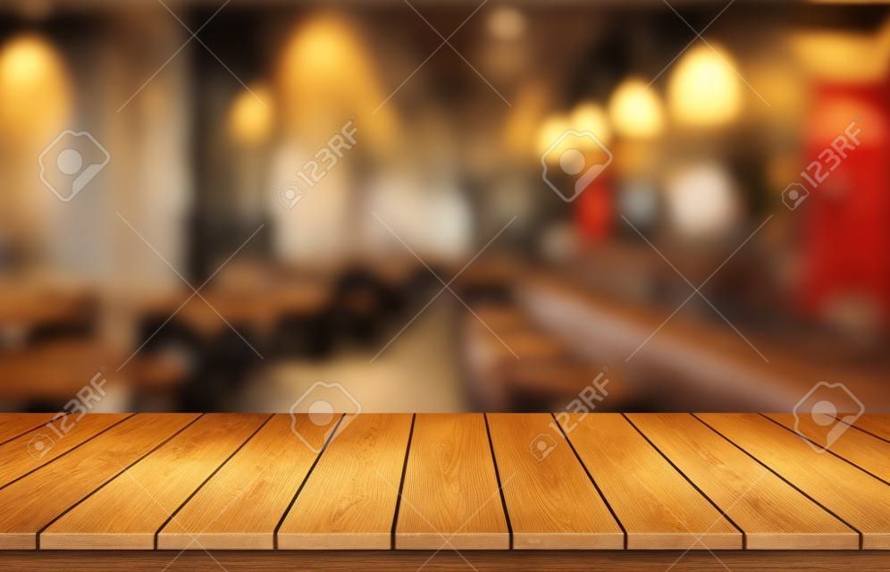 Holztischplatte auf verschwommenem Restaurant- oder Café-Hintergrund. Für die Montage von Produktdisplays oder Design-Key-Visual-Layouts. Ansicht des Kopierraums.