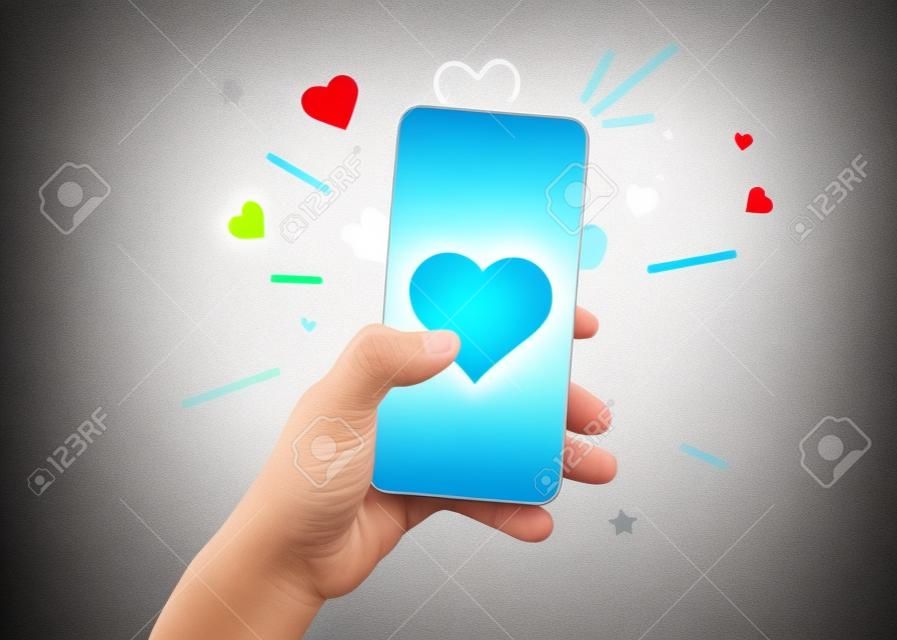 Hand holding phone with heart symbol. Social networking concept.
