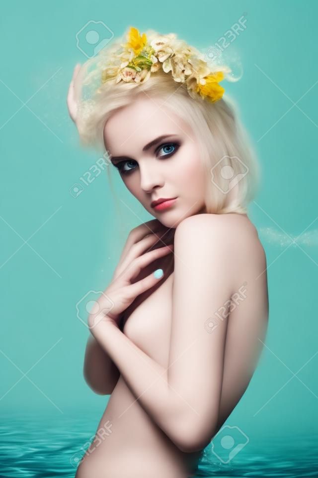 Art divat portré, fiatal szőke lány virággal a haja vízben