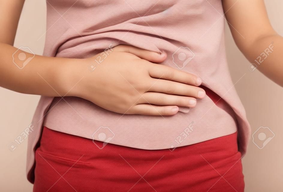 mujer con dolor tiene su mano sobre el estómago