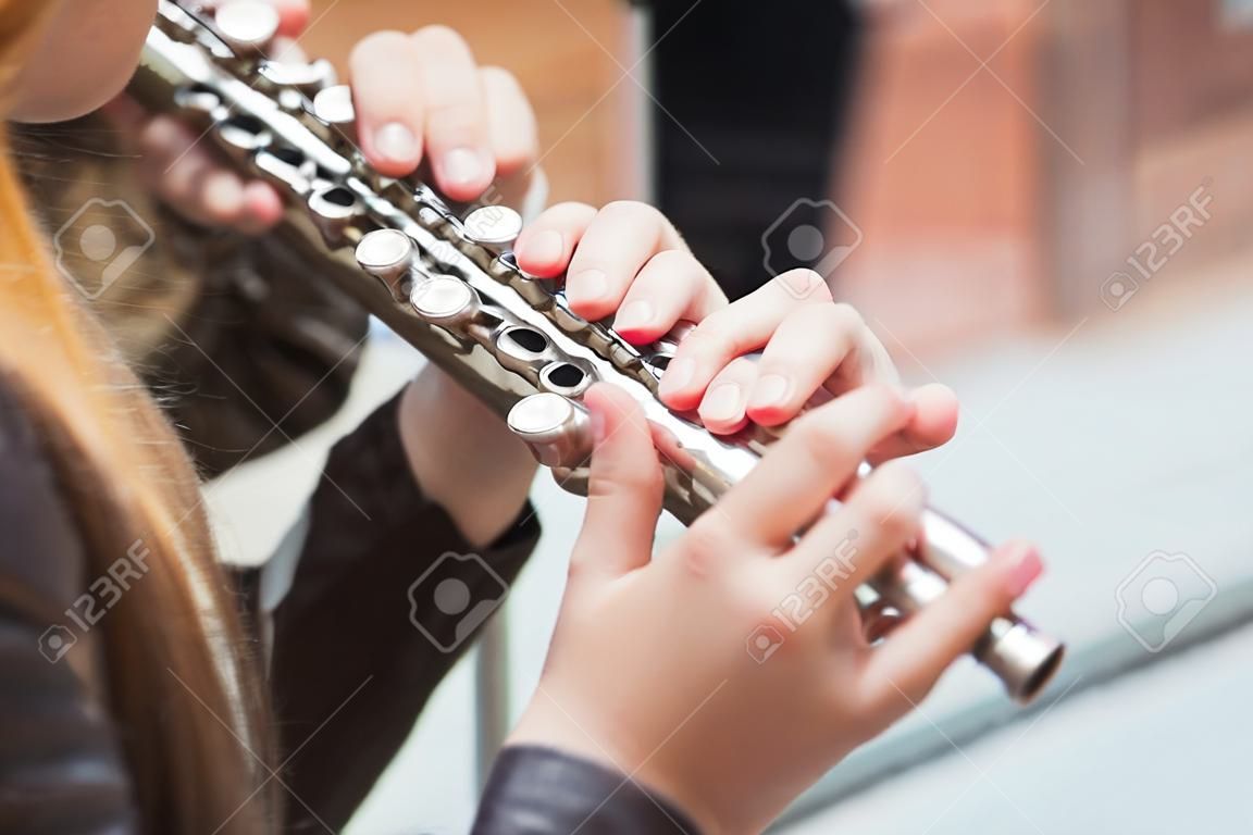A girl plays a flute on a street concert