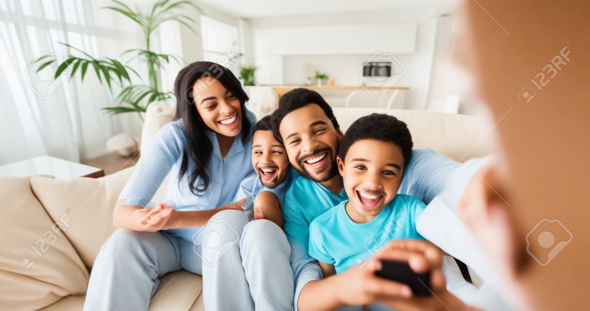 Portrait of happy family taking selfie in living room in slow motion. Concept of communication, connection, technology, lifestyle, social, family.