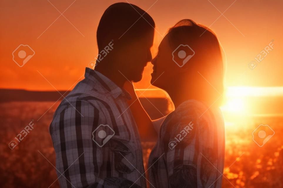 Hermosa pareja juntos viendo una hermosa puesta de sol.
