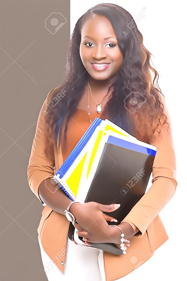 Beautiful african student woman posing isolated over white background