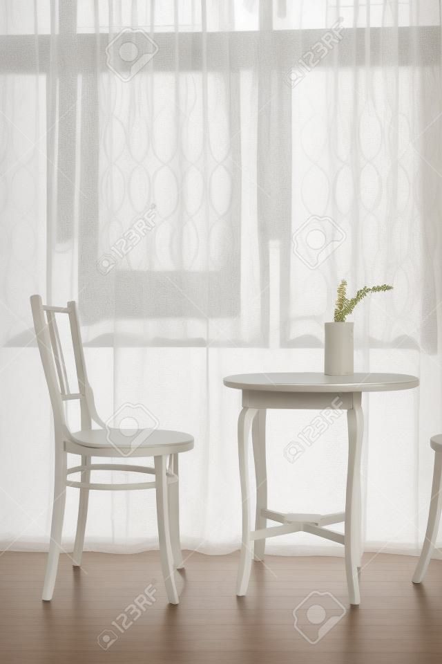 conjunto de mesa y silla vintage además de ventana con cortina transparente